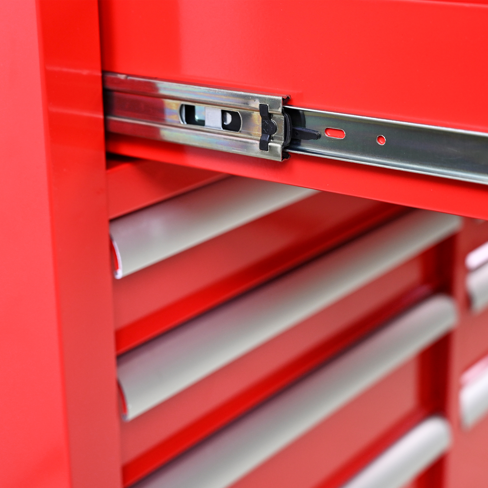 Closeup of red metal tool chest drawer slides showing ballbearing action