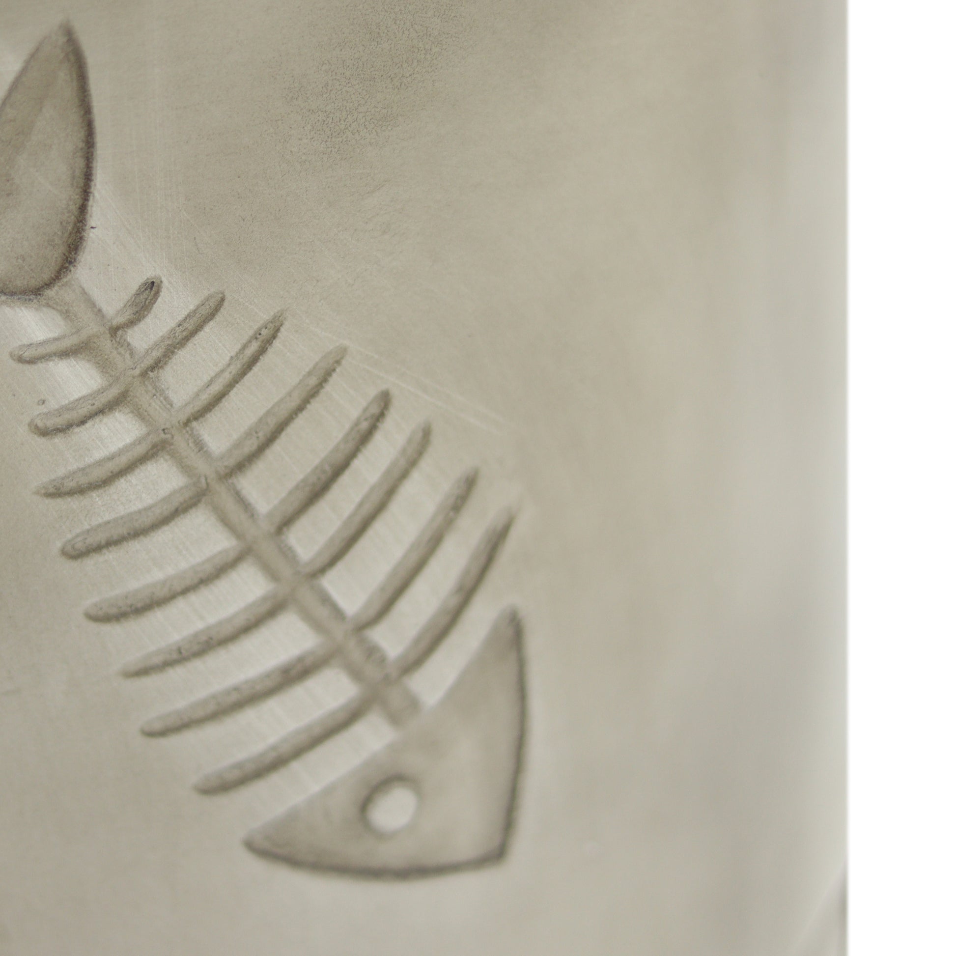 Etched fish bone pattern on a textured ceramic mug perfect for coffee lovers