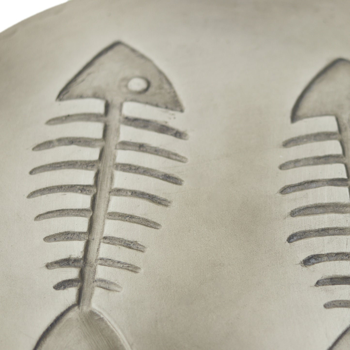 Closeup of two grey ceramic fish skeleton emblems a charming detail for coastal decor