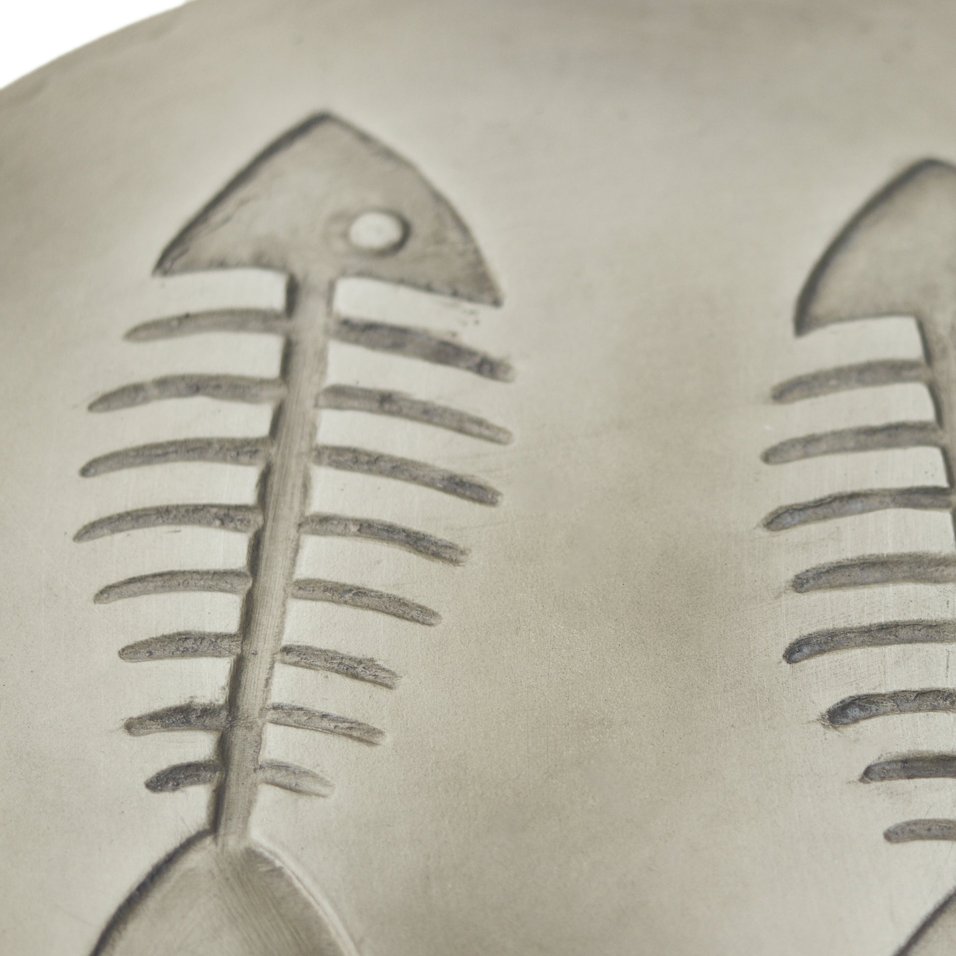 Closeup of two grey ceramic fish skeleton emblems a charming detail for coastal decor