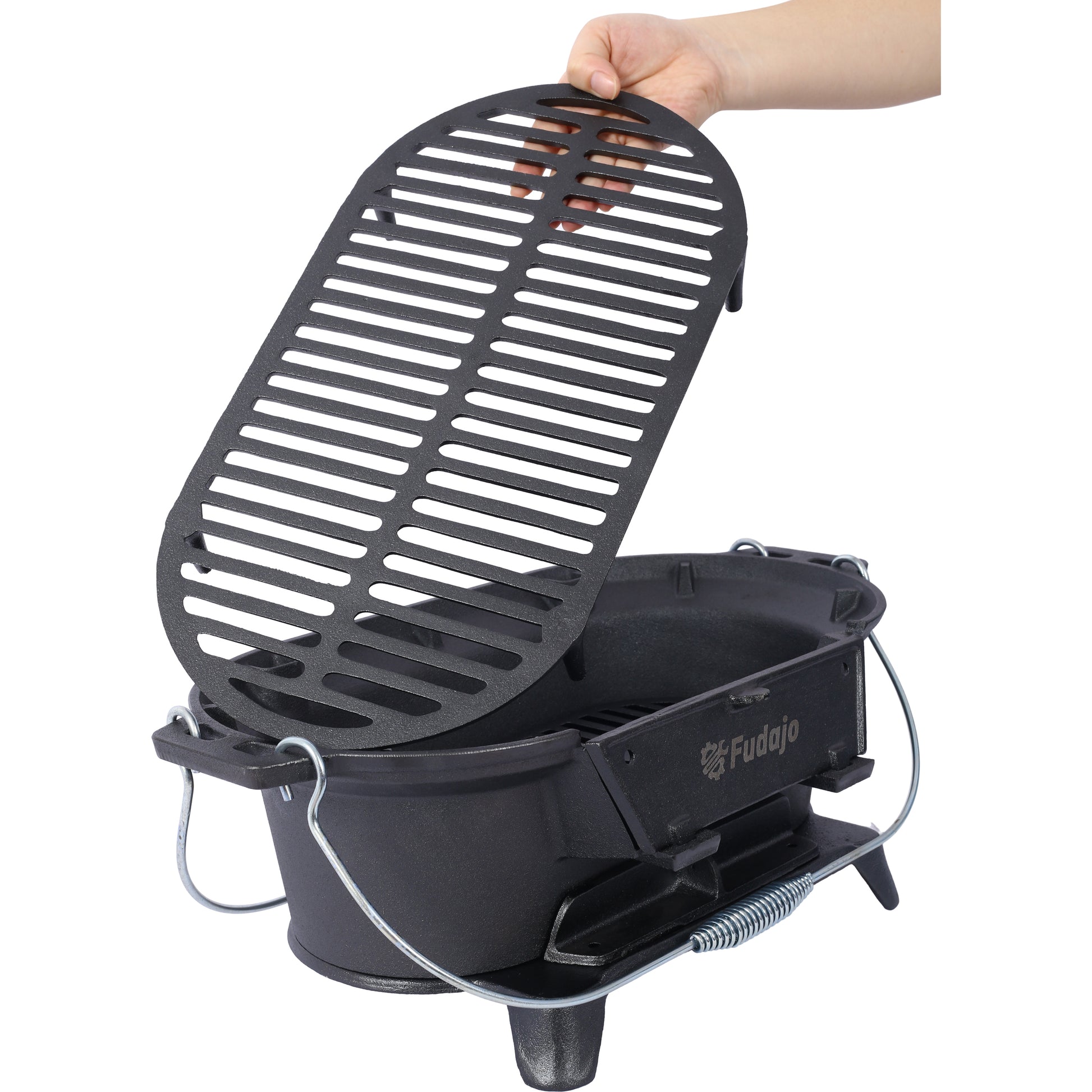 Black cast iron portable grill with a hinged lid being lifted by a hand