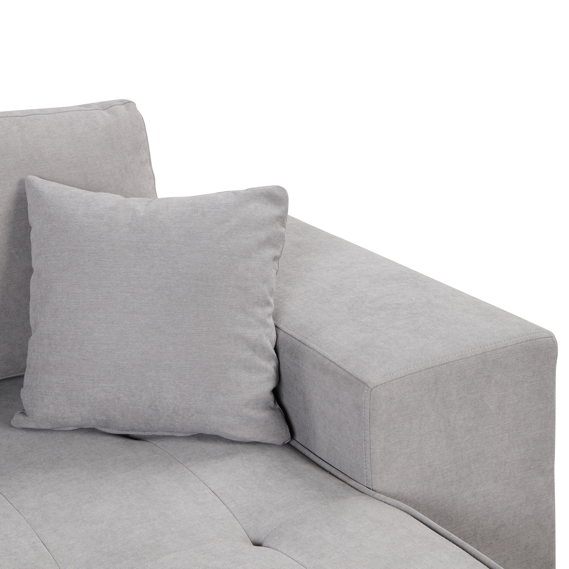 Light gray fabric sectional sofa with tufted seat and one accent pillow