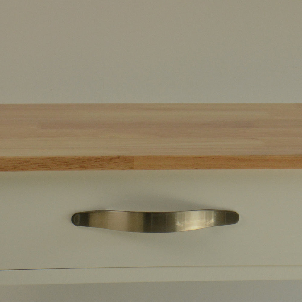 Brushed nickel cabinet drawer pull on a creamcolored drawer front