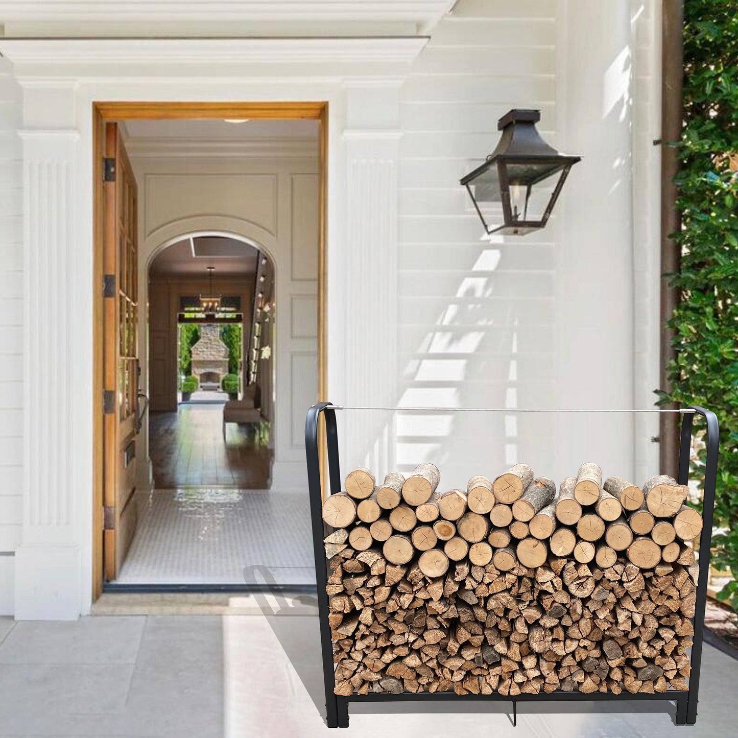 Black metal firewood rack filled with split and whole logs on a porch
