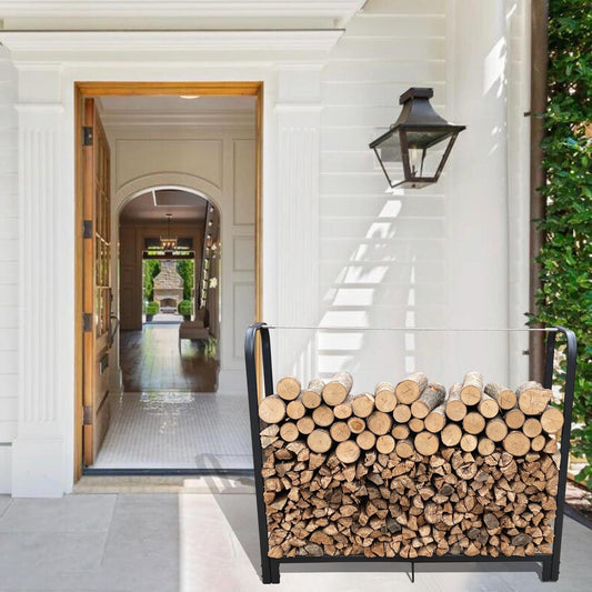 Black metal firewood rack filled with split and whole logs on a porch
