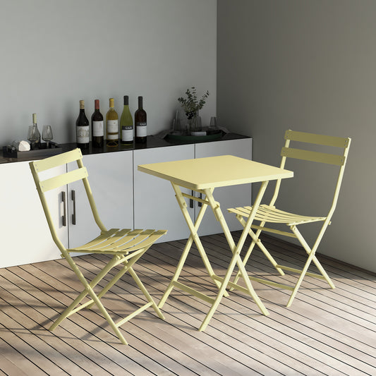 Pale yellow metal bistro set with two chairs and a square table on a wooden deck