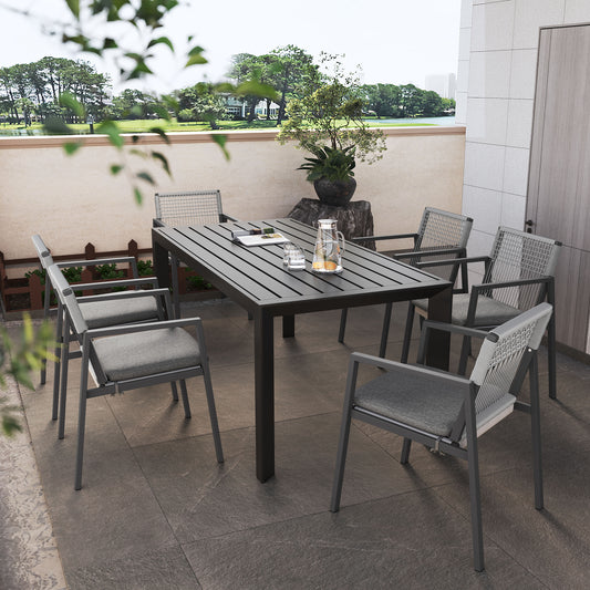 Modern dark grey metal outdoor dining table with slatted top and grey chairs