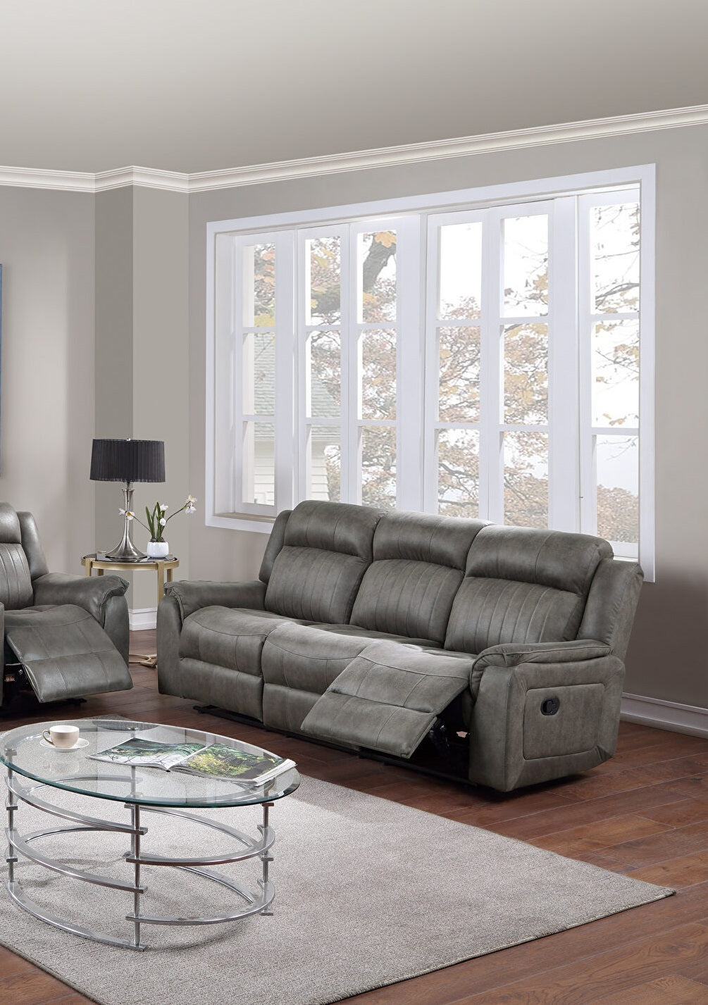 Gray leather threeseater recliner sofa with plush cushioning and adjustable footrests