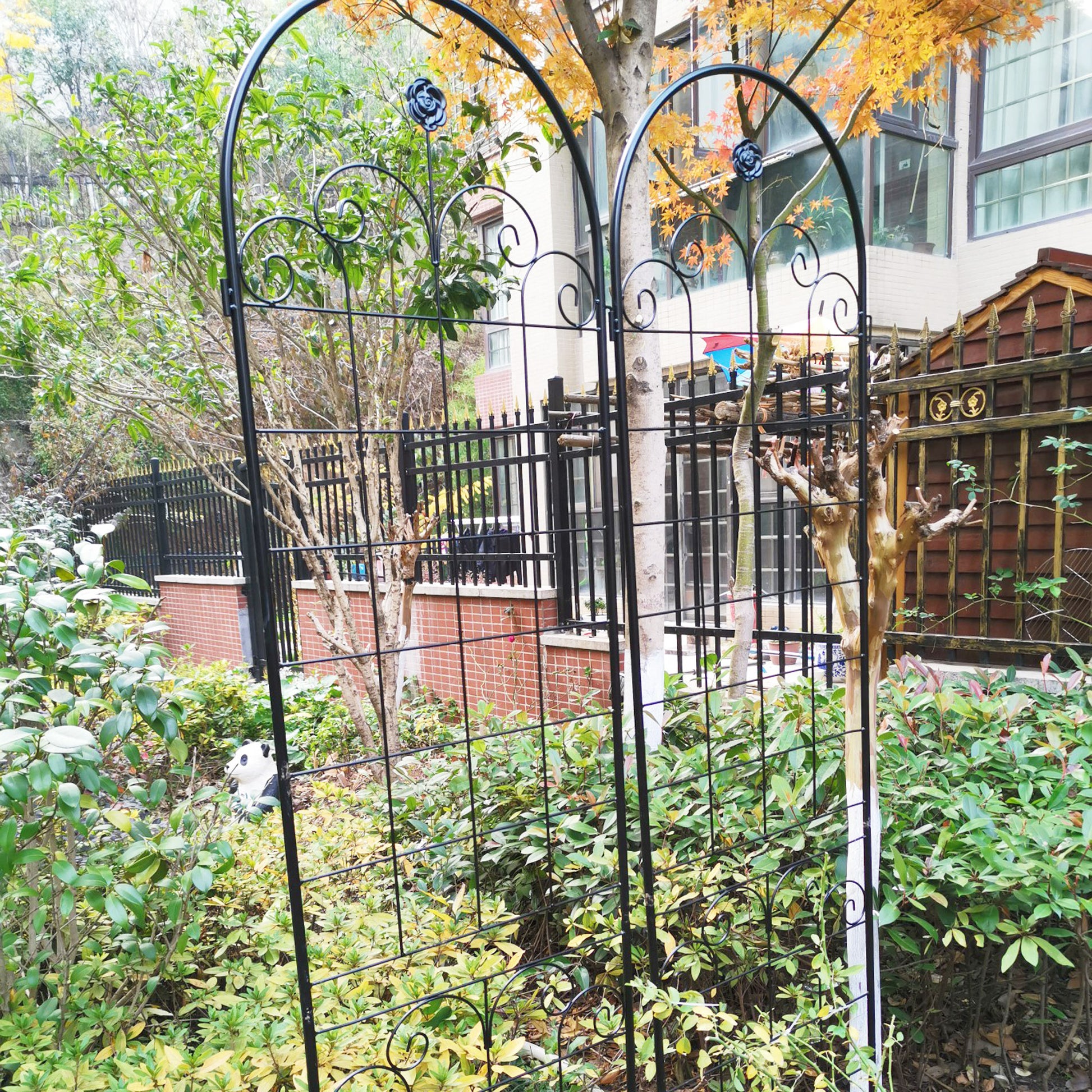 Black wrought iron garden trellis with rose accents for climbing plants
