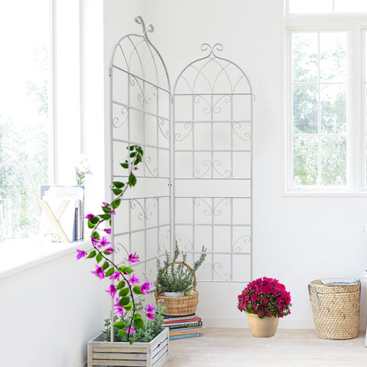 Elegant white metal garden trellis with ornate scrollwork for climbing plants
