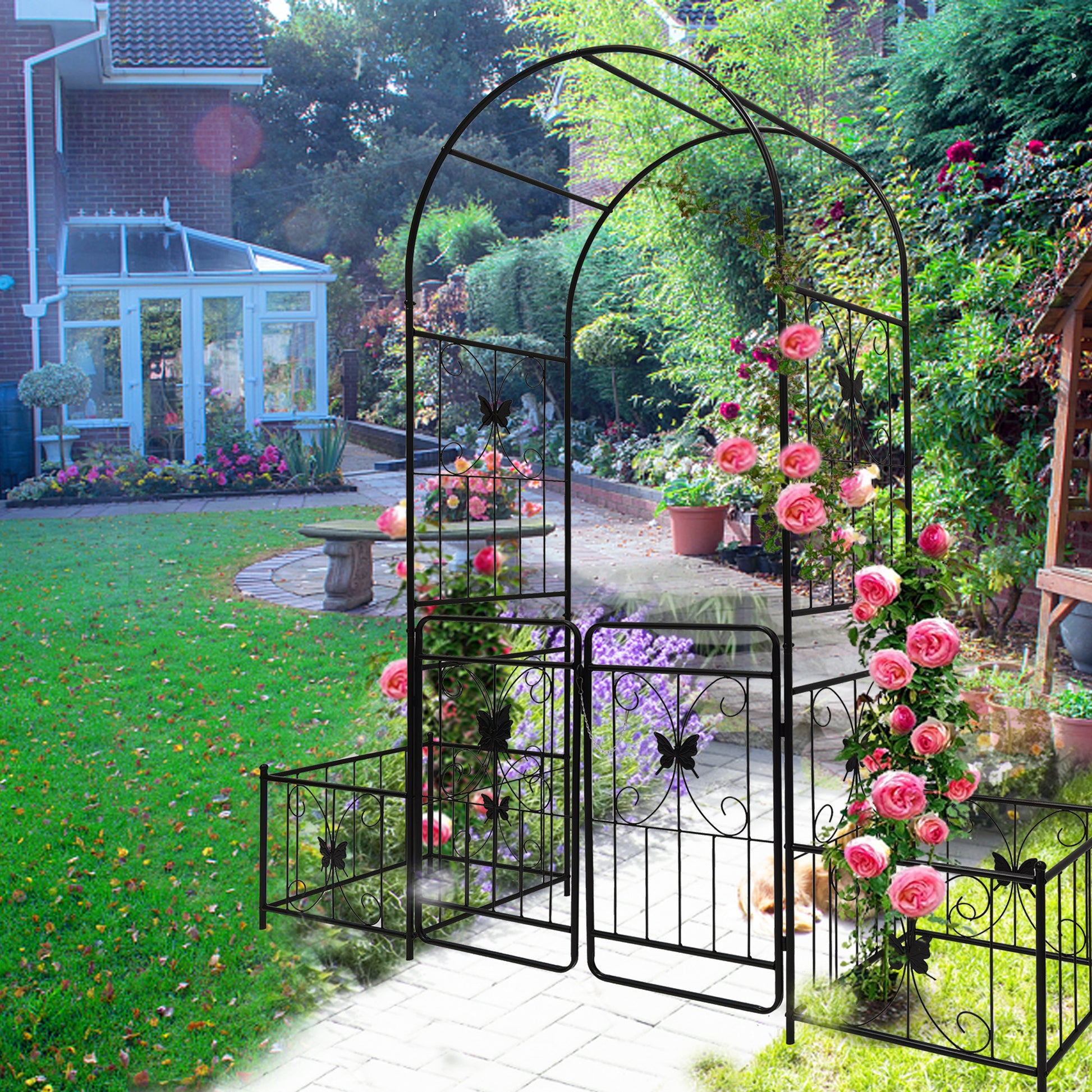 Black wrought iron garden arch with butterfly accents and climbing roses