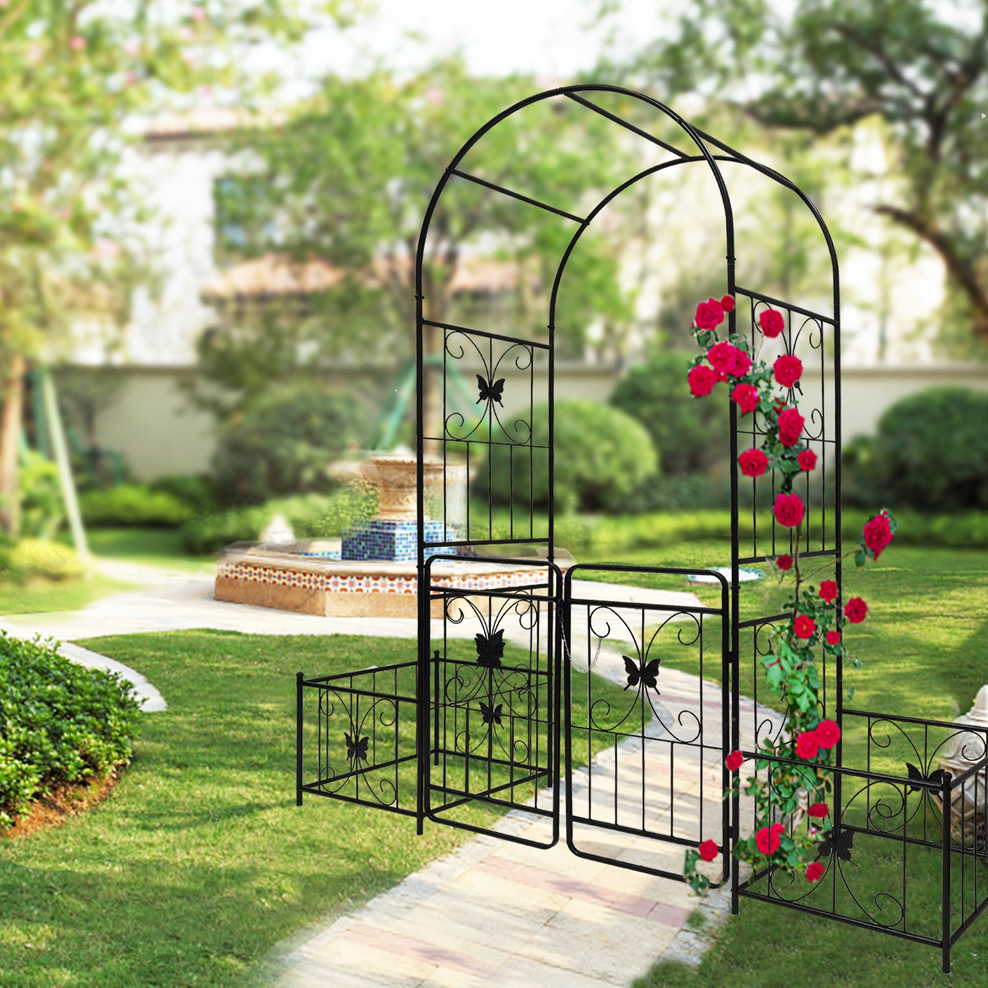 Black metal garden arch with butterfly accents and climbing roses
