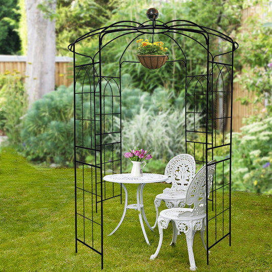 Black metal garden arch with ornate scrolling and hanging flower basket