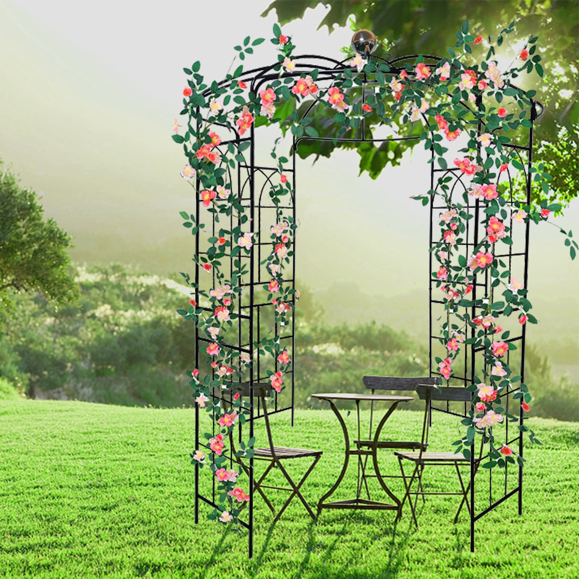 Black metal garden arbor entwined with pink and white roses featuring a bistro set on lush green lawn