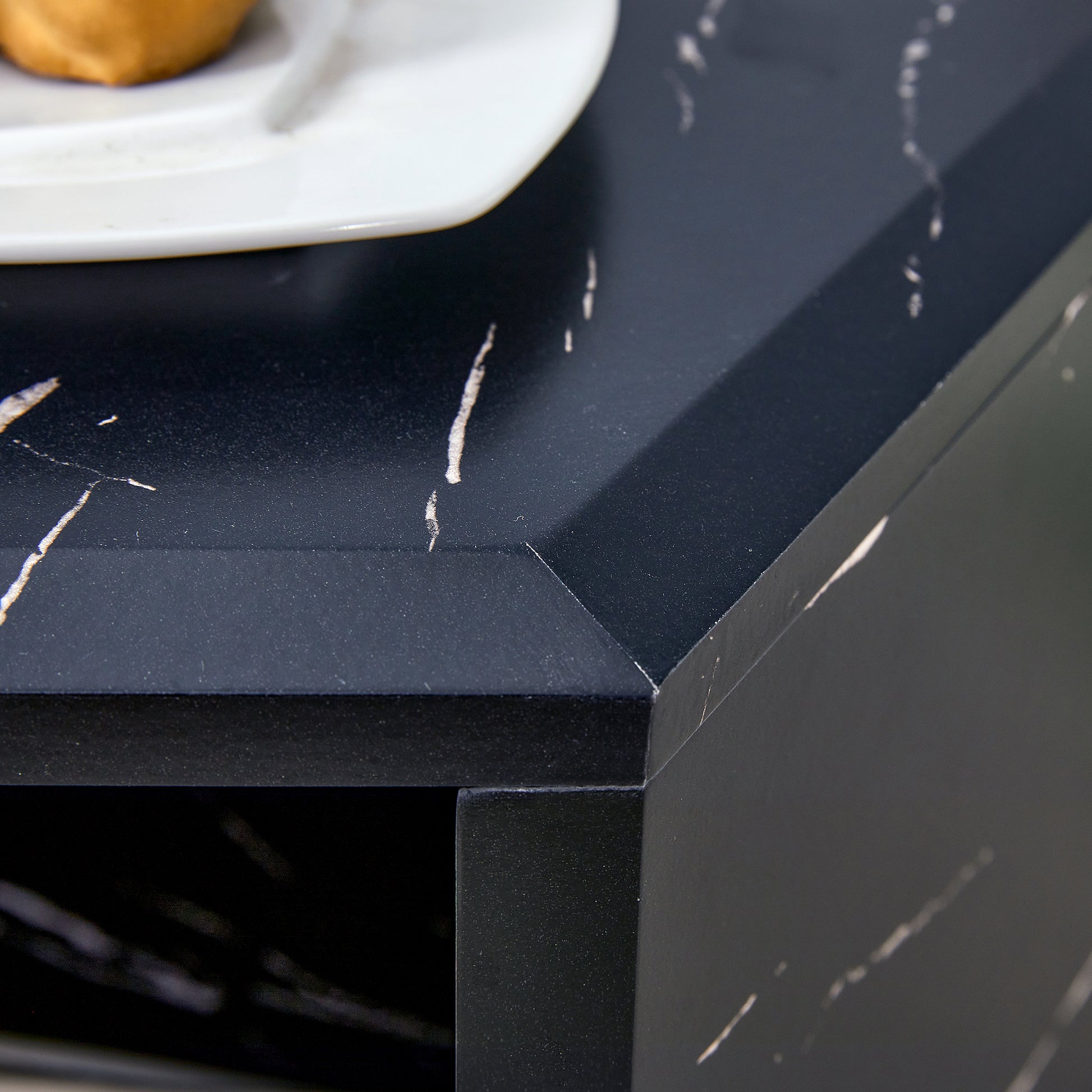 Black marble effect countertop with white veining and a beveled edge