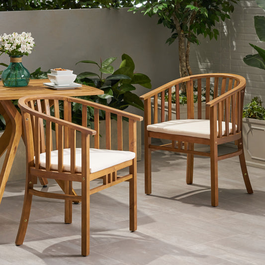 Two curved back wooden patio chairs with cream cushions perfect for outdoor relaxation
