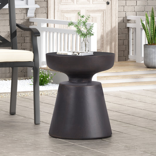Dark bronze modern outdoor accent table with pedestal base holding a book
