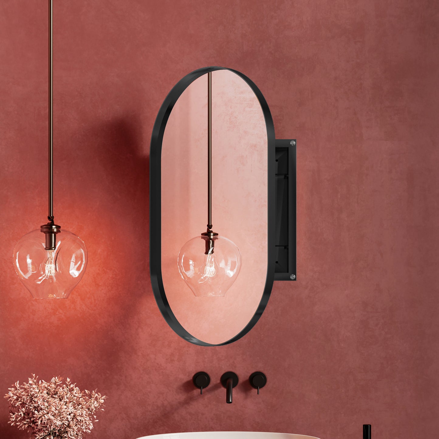 Oval black framed bathroom mirror with copper accents reflecting a pendant light