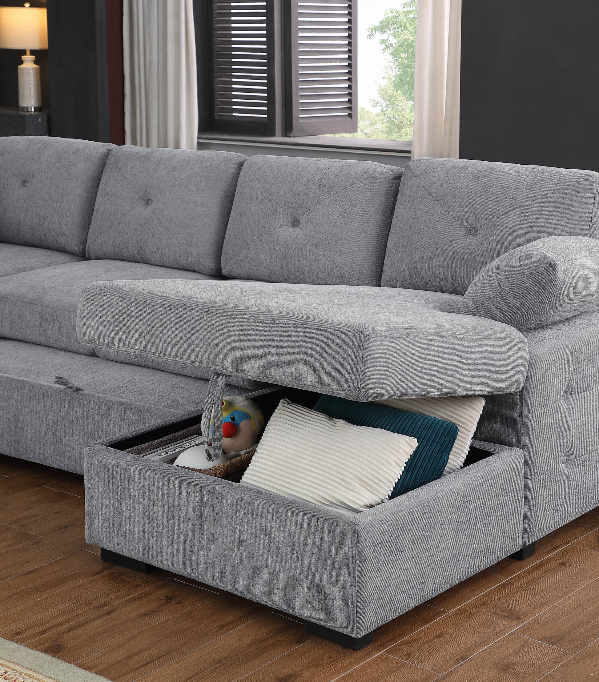 Grey sectional sofa with hidden storage compartment filled with pillows