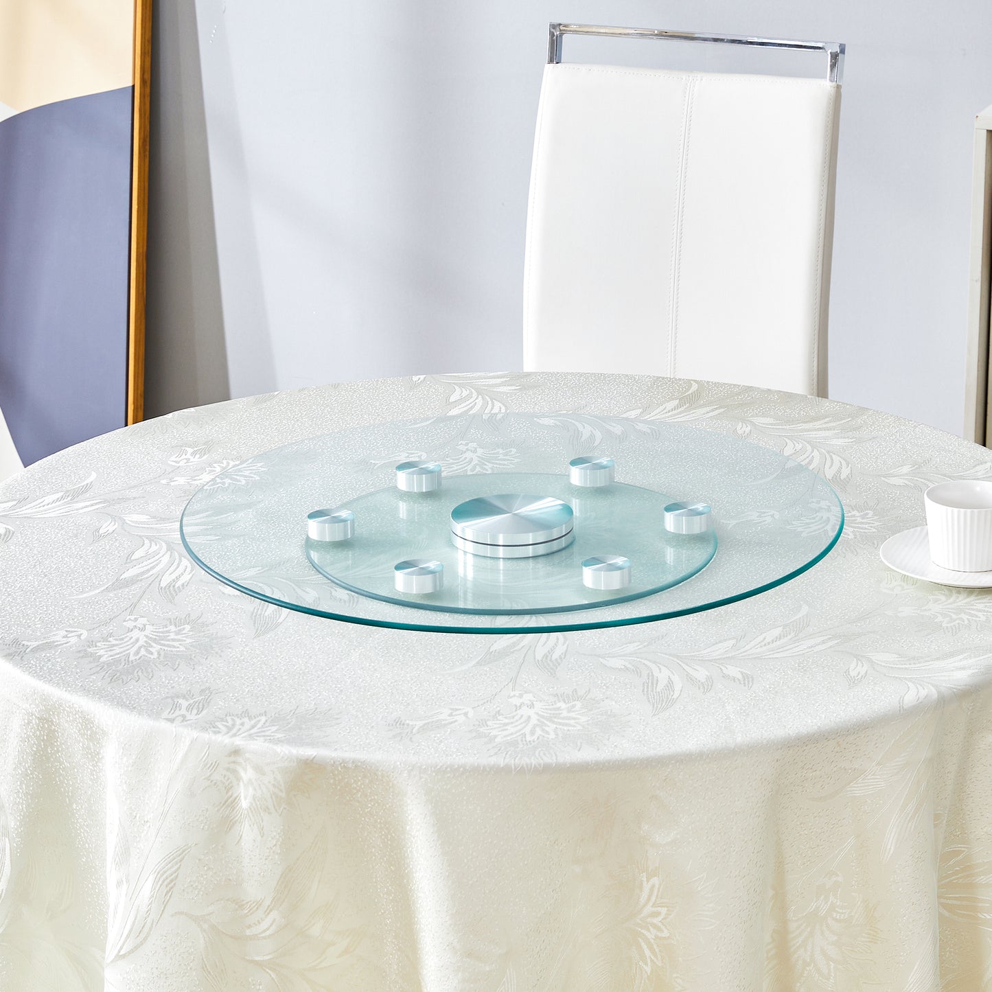 Clear glass lazy Susan with silver accents on a patterned tablecloth