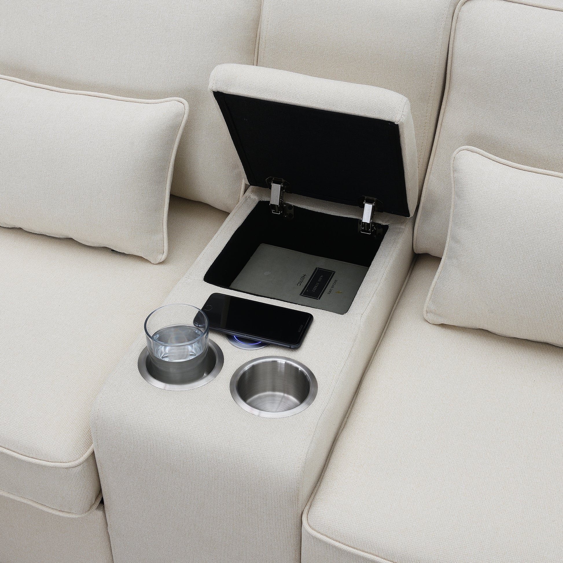 Beige fabric sofa with builtin storage compartment cup holders and phone charging pad