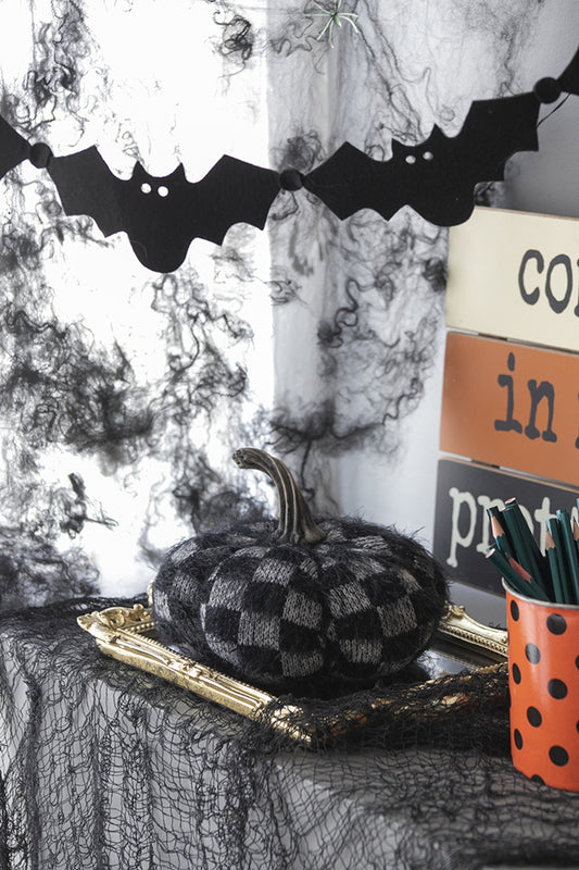 Textured checkered Halloween pumpkin decoration on a gilded frame