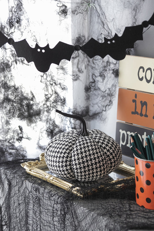 Houndstooth fabric pumpkin with black stem on ornate gold tray