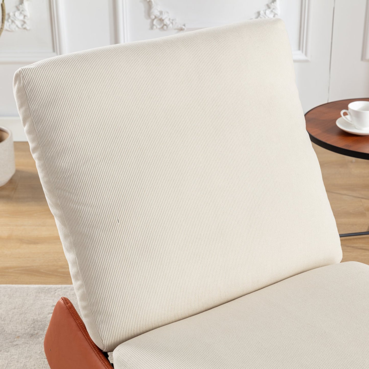 Cream corduroy armchair with rich brown leather accents and plush cushioning