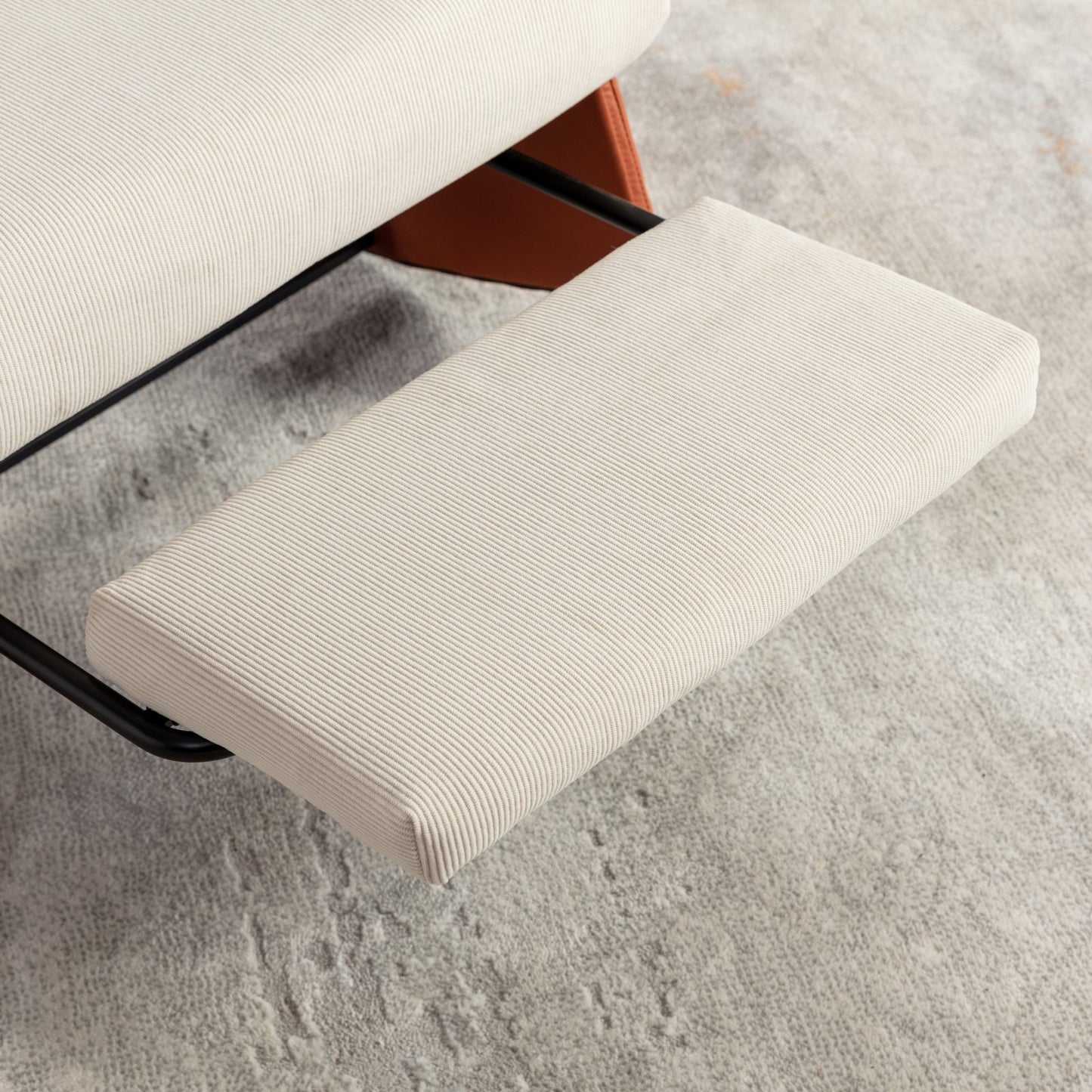 Closeup of a modern corduroy ottoman in a neutral cream color complementing a grey textured rug