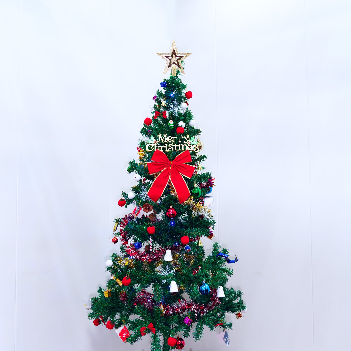 Decorated artificial Christmas tree with red bow and star topper