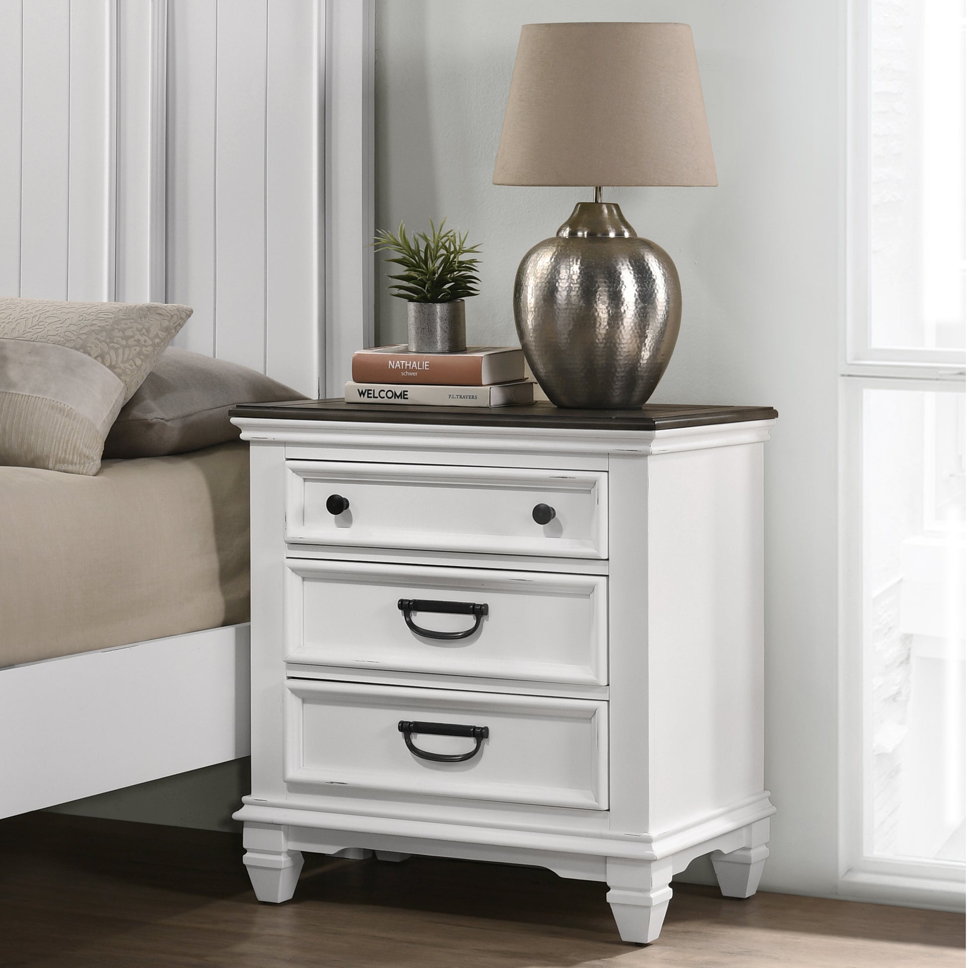 White farmhouse nightstand with three drawers and dark metal hardware