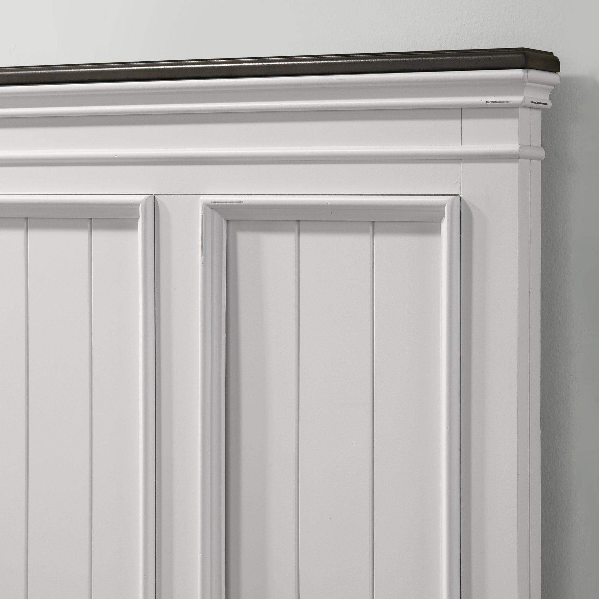 White raised panel cabinet door with dark wood trim accent