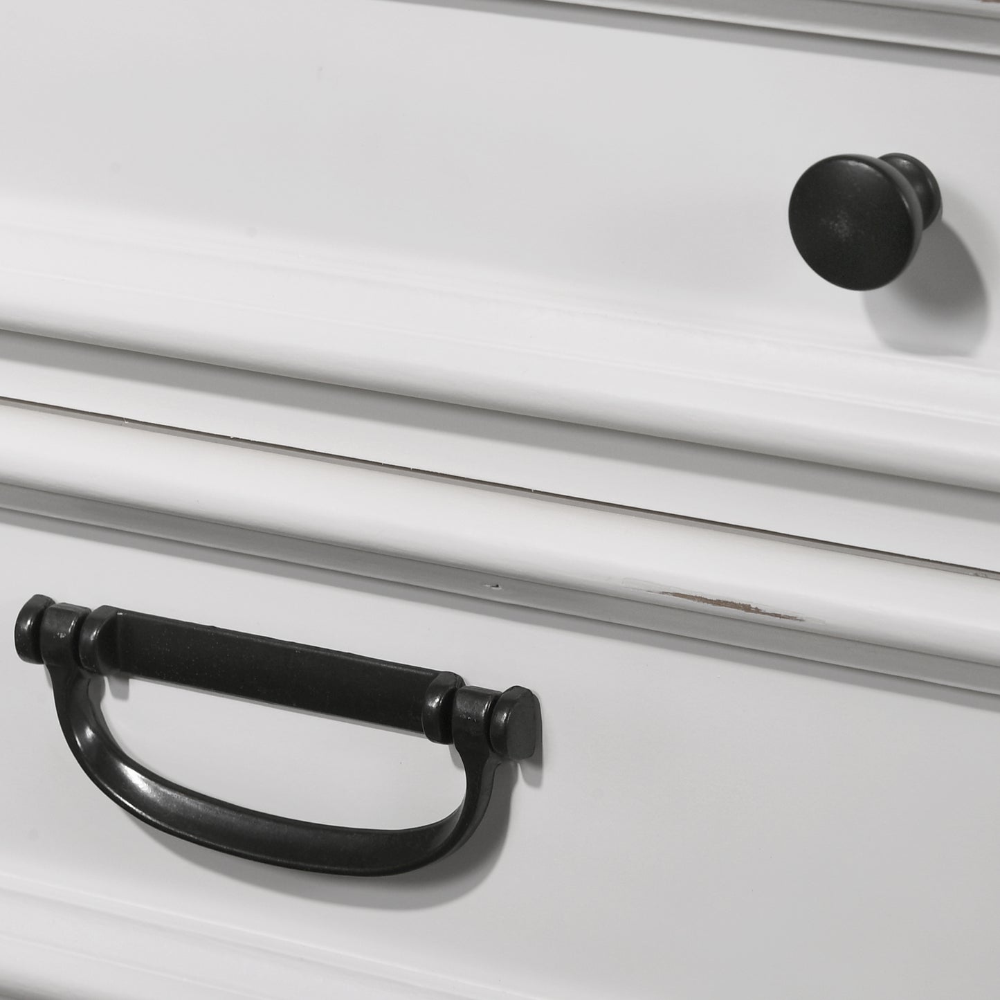 White dresser drawer with ornate black pull handle