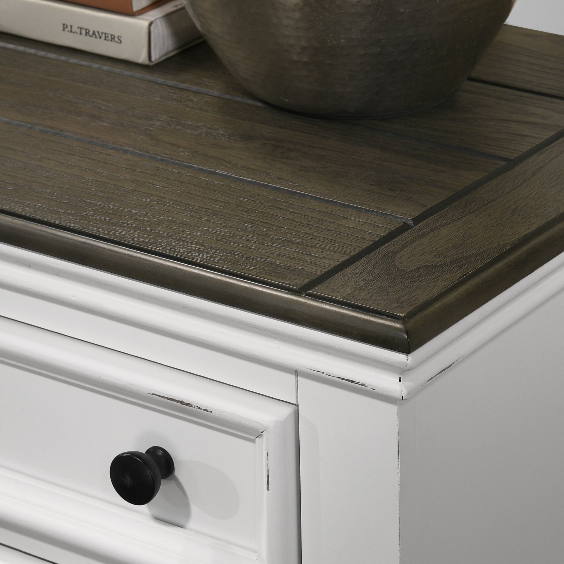 White dresser with dark wood top and black knob