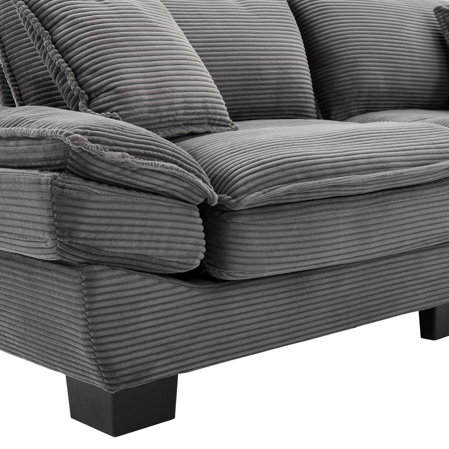 Closeup of a comfortable grey corduroy sectional sofa with plush cushions and wooden legs