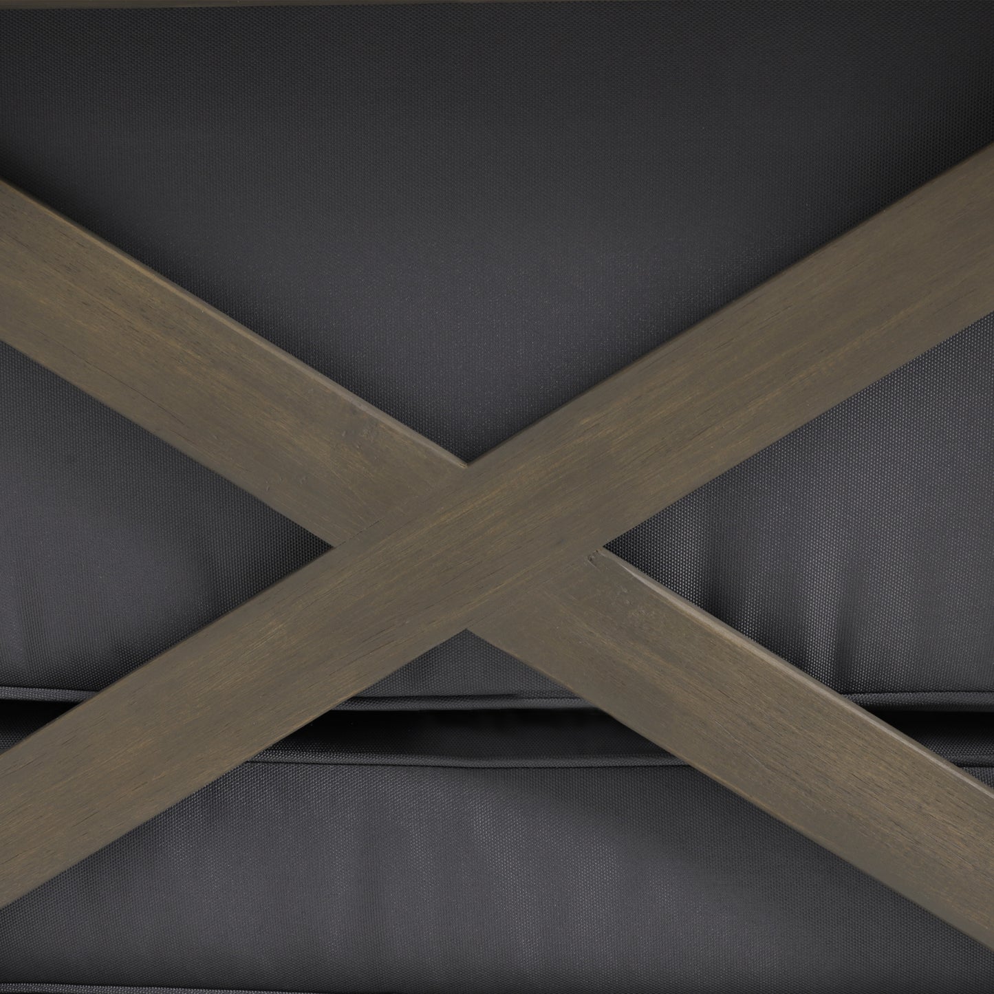 Distressed wood Xbrace detail on a dark grey upholstered ottoman