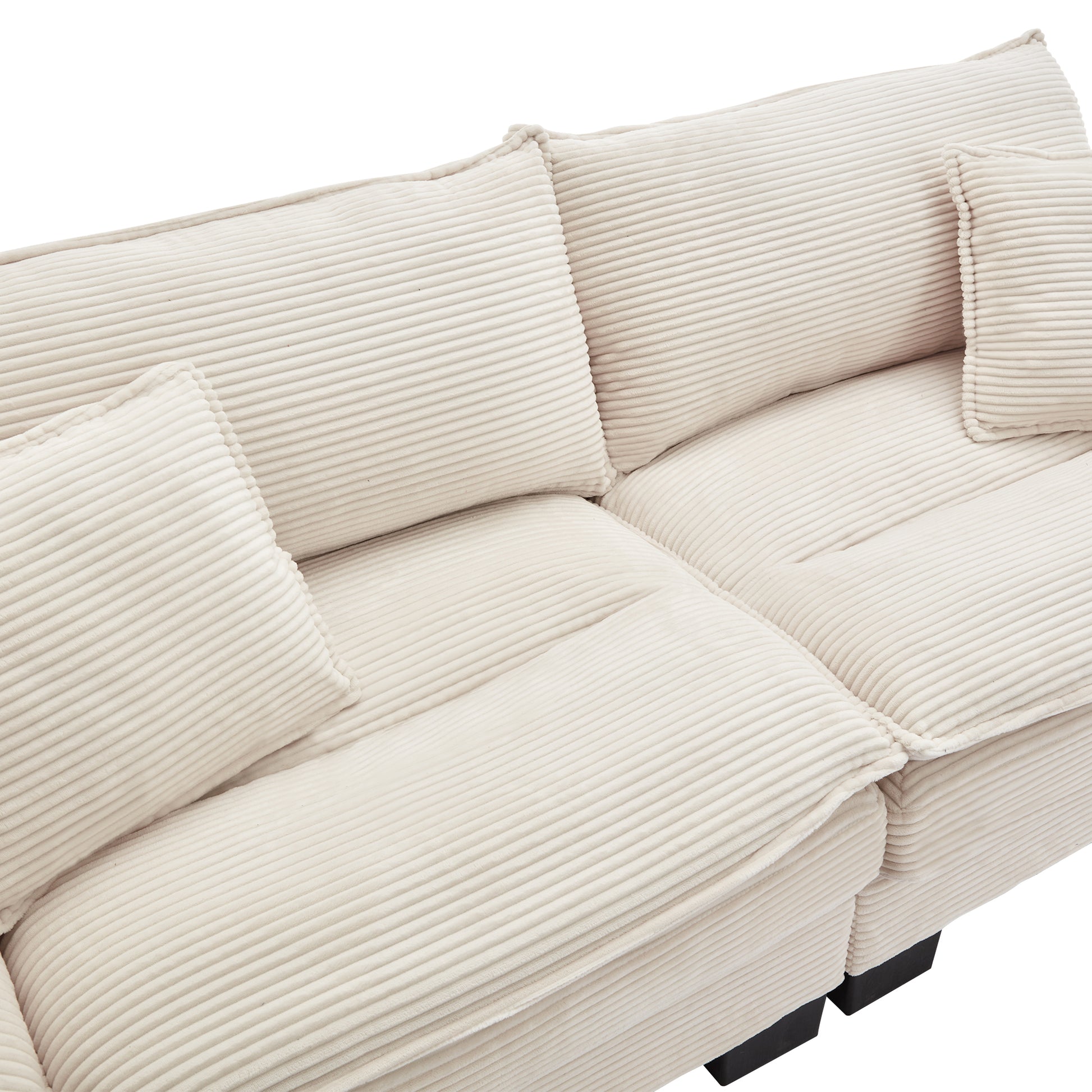Cream corduroy sectional sofa with plush cushions and dark wood legs creating a cozy living room focal point