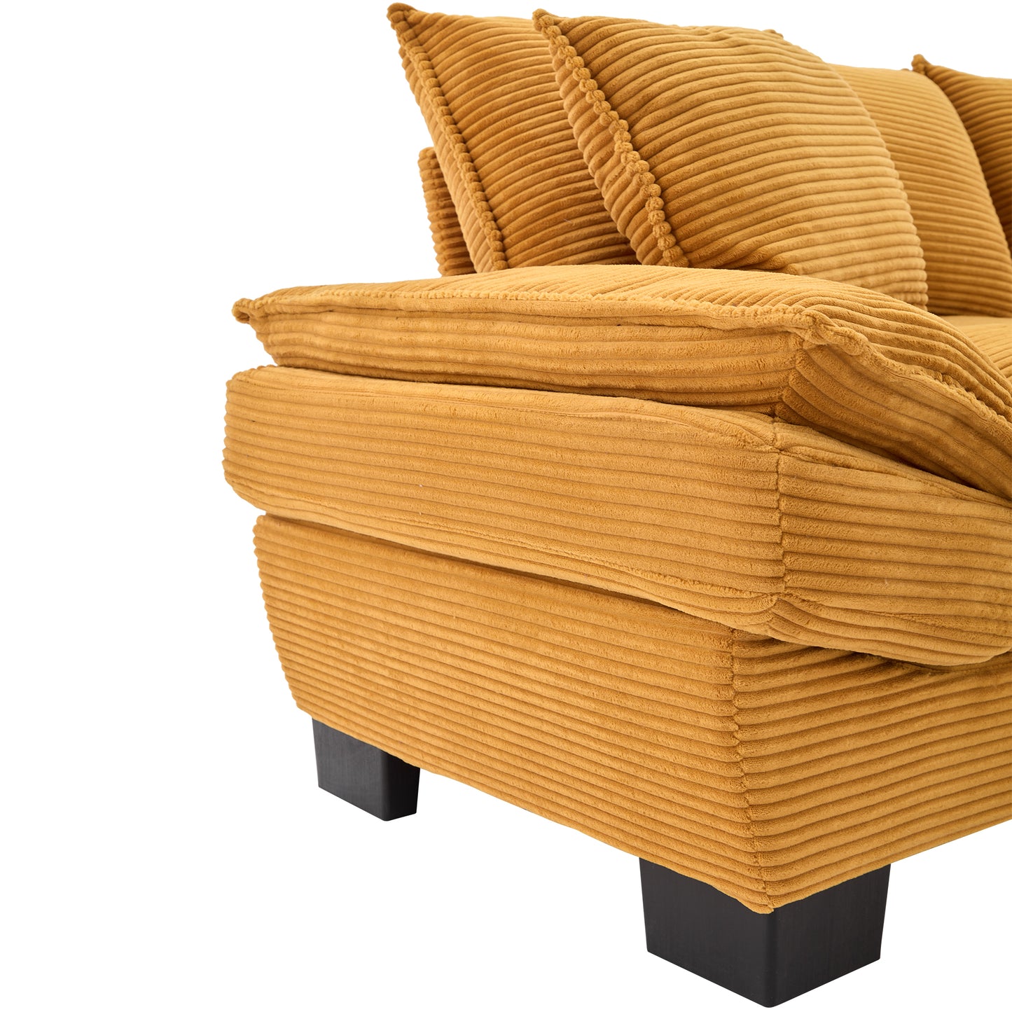 Closeup of a textured mustard yellow corduroy sofa showing plush seat cushions and back pillows