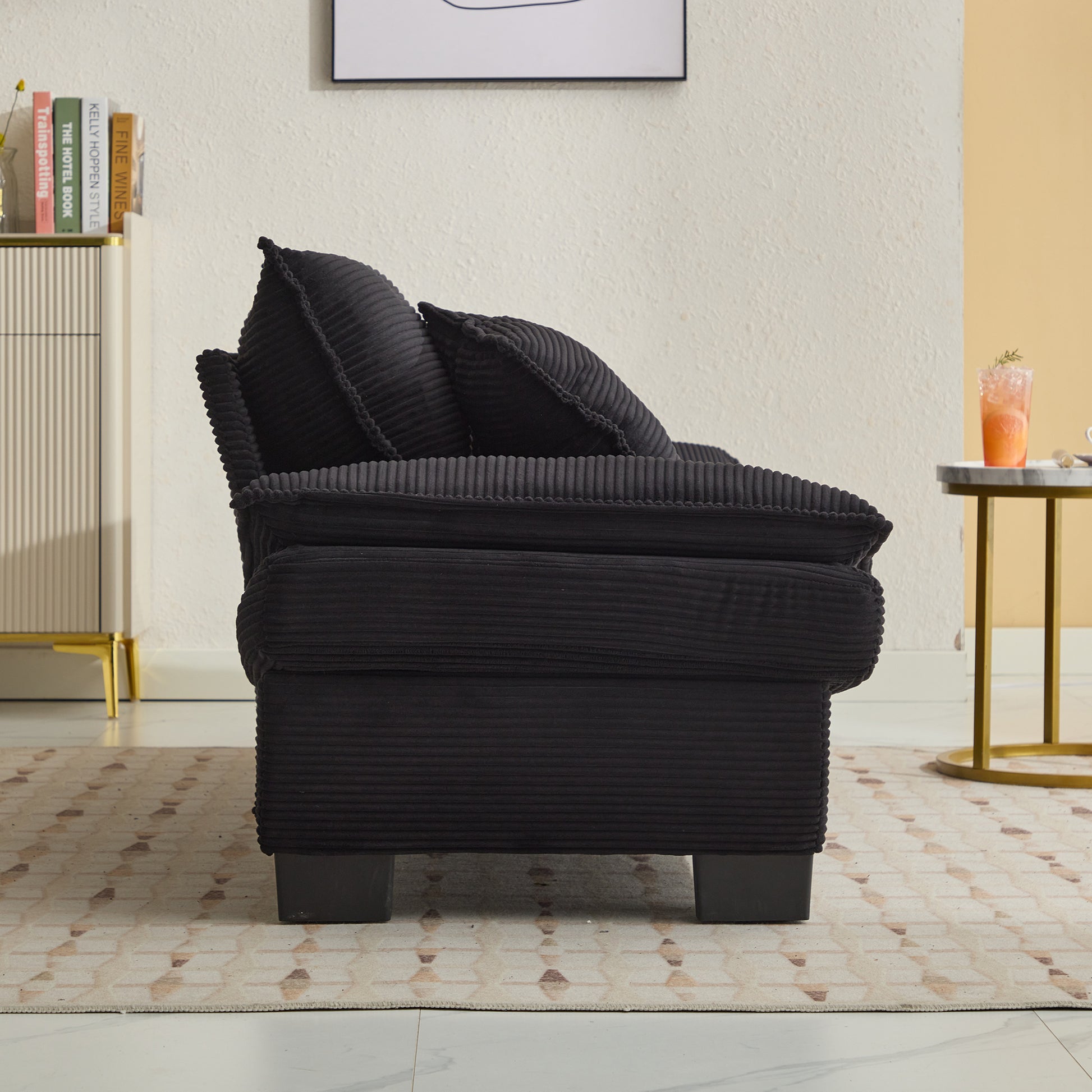 Black corduroy sofa with plush accent pillows perfect for a cozy living room