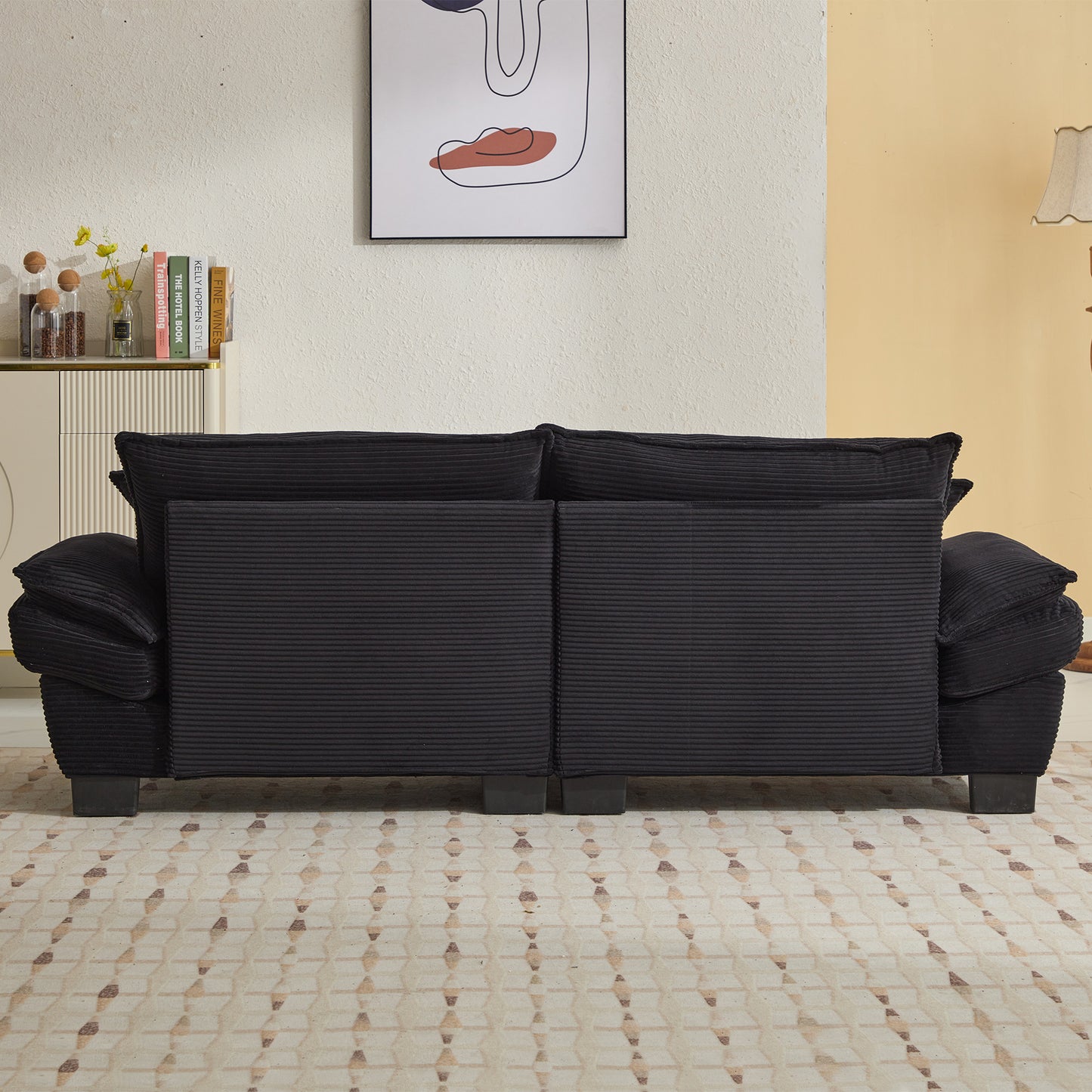Black corduroy sofa with deep plush cushions and dark wood legs