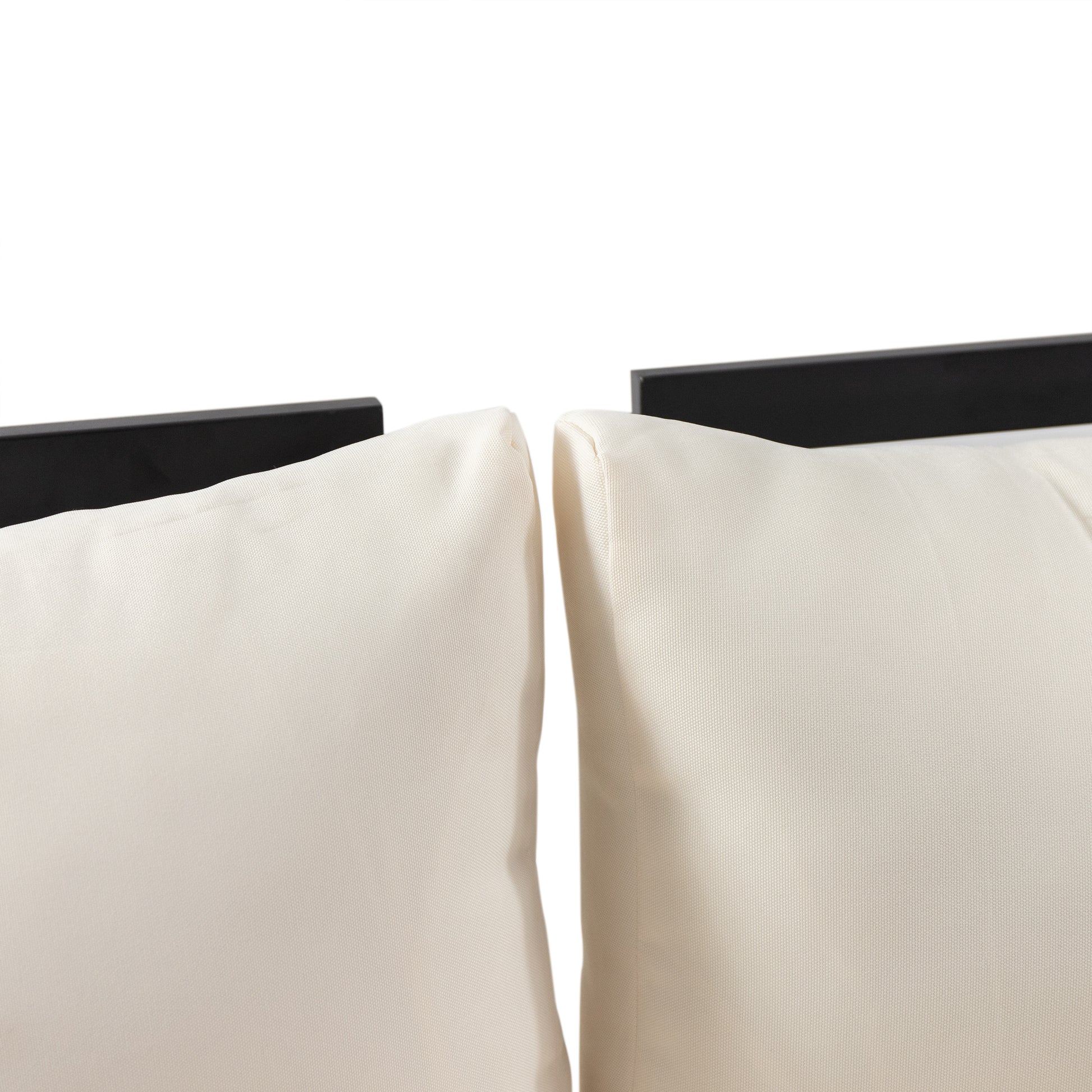 Closeup of two beige outdoor patio cushions with textured fabric and black framing