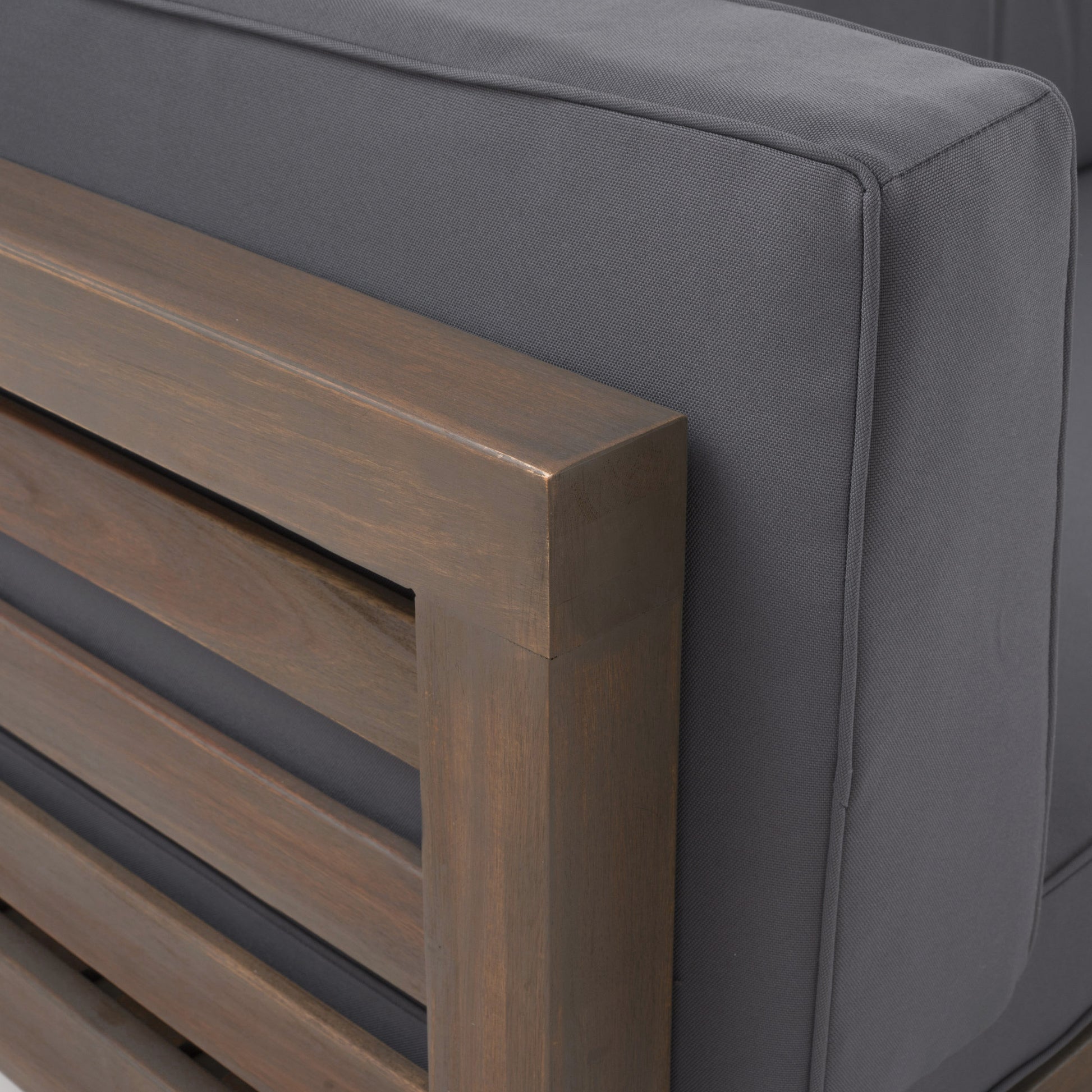 Closeup of dark grey outdoor sofa cushion fabric with piped edge