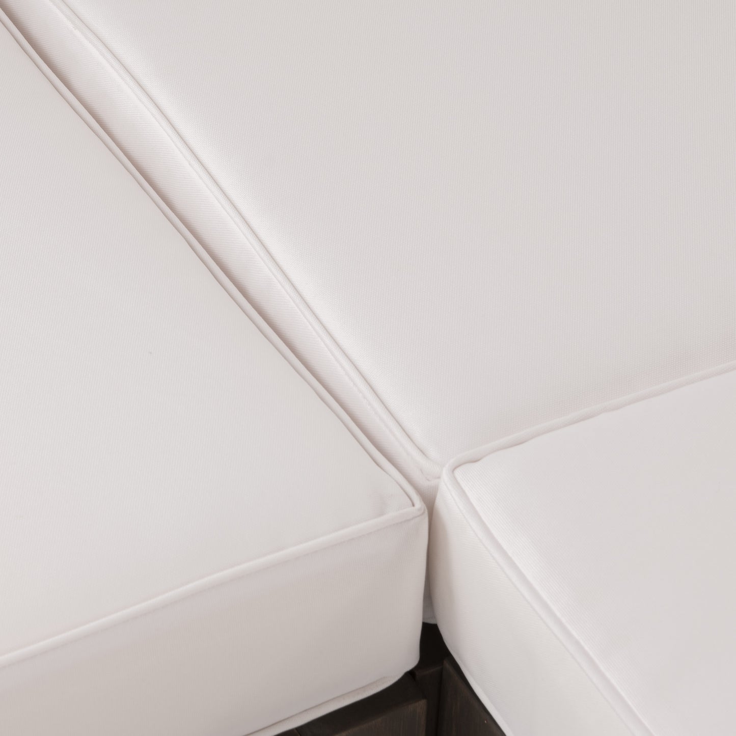 Closeup of plush white outdoor sofa cushions with piped edges for comfort