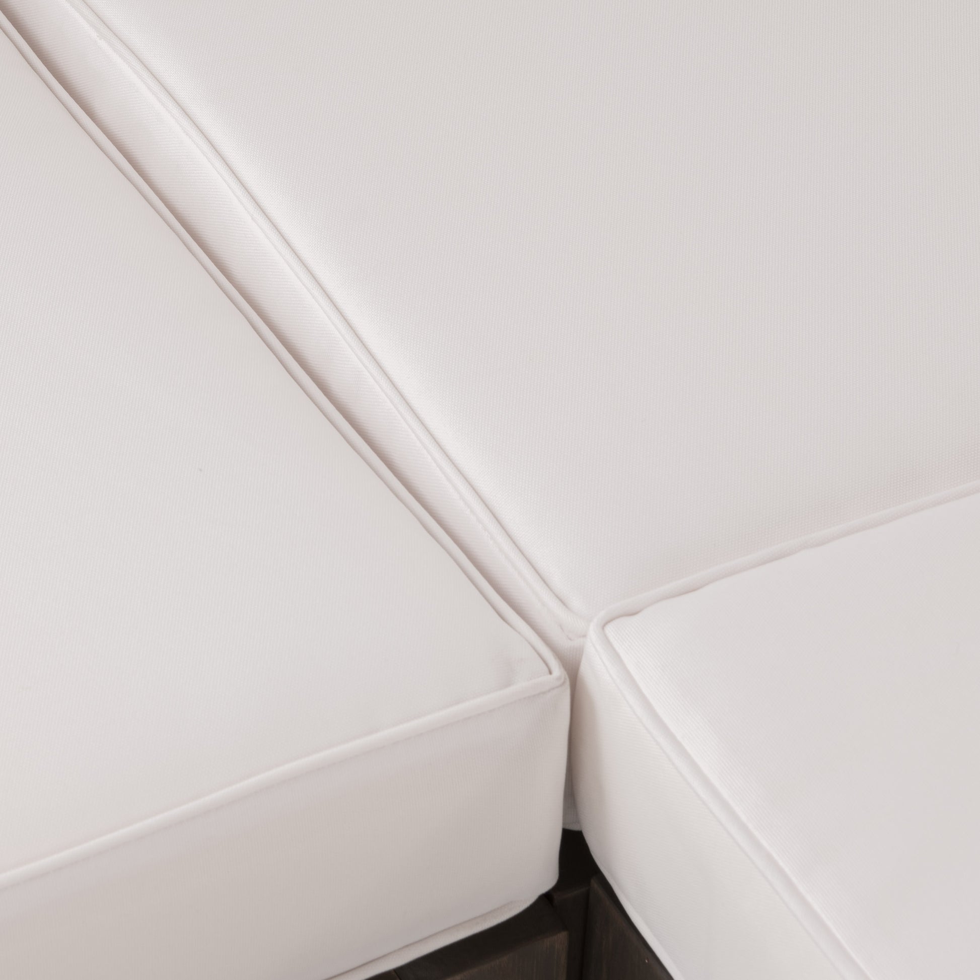 Closeup of plush white outdoor sofa cushions with piped edges for comfort