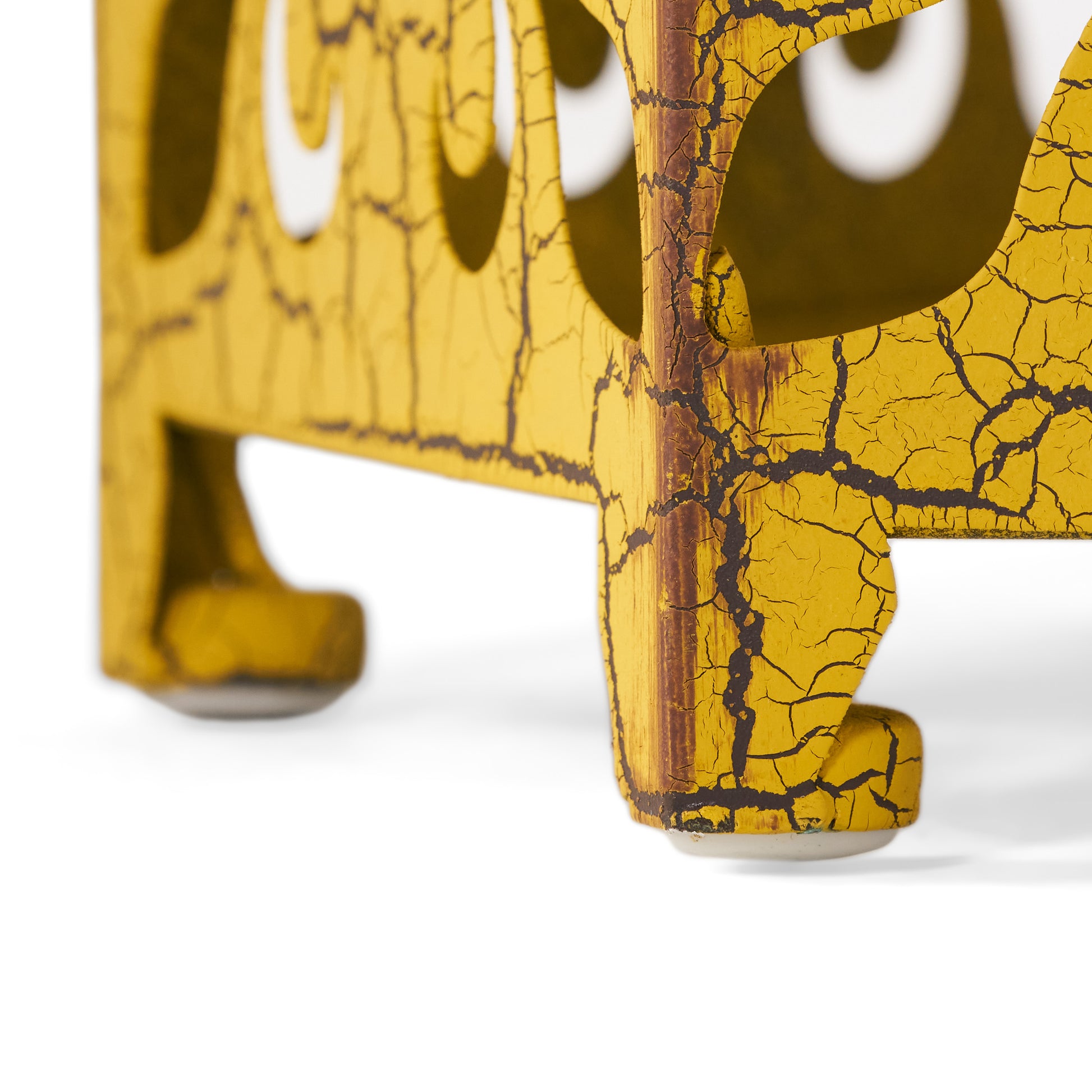 Yellow vintage metal sign with cracked paint detail displaying a distressed aesthetic