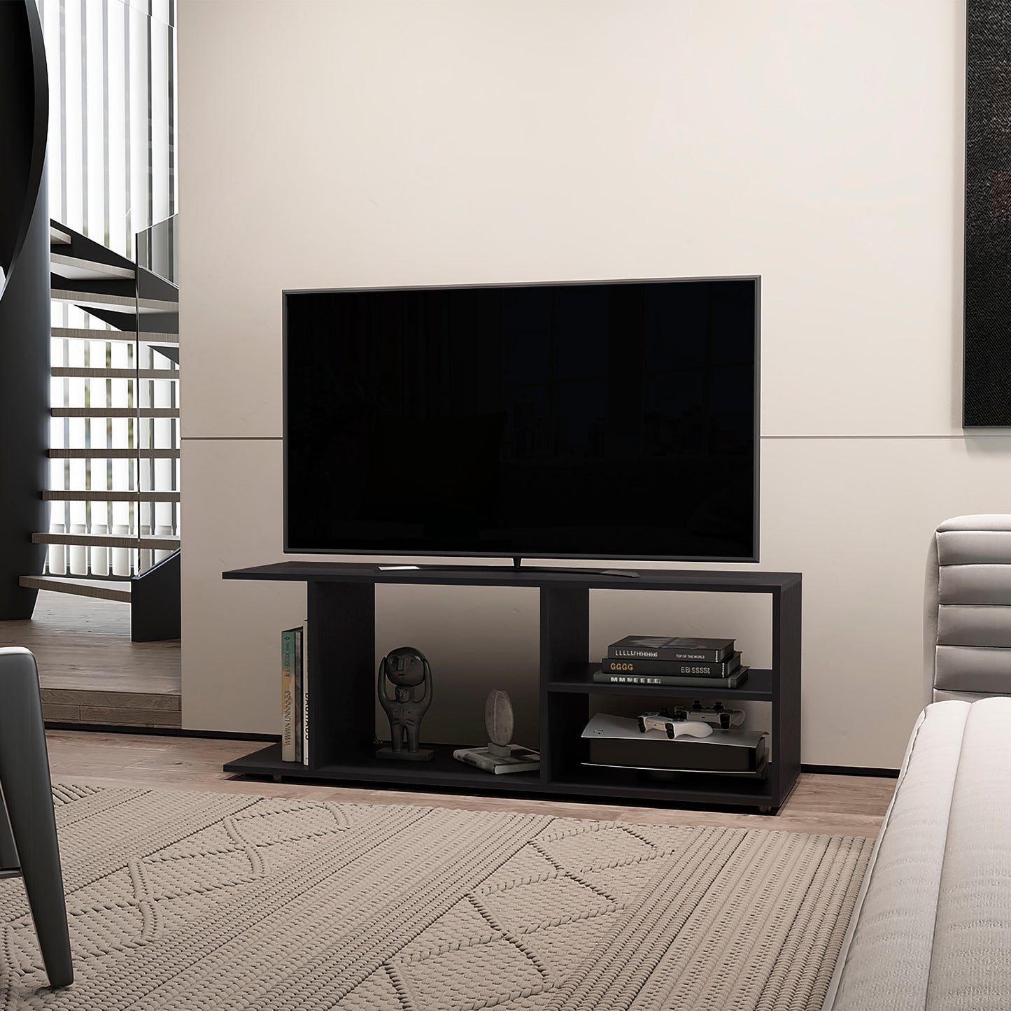 Black media console with open shelves holding books and a game console