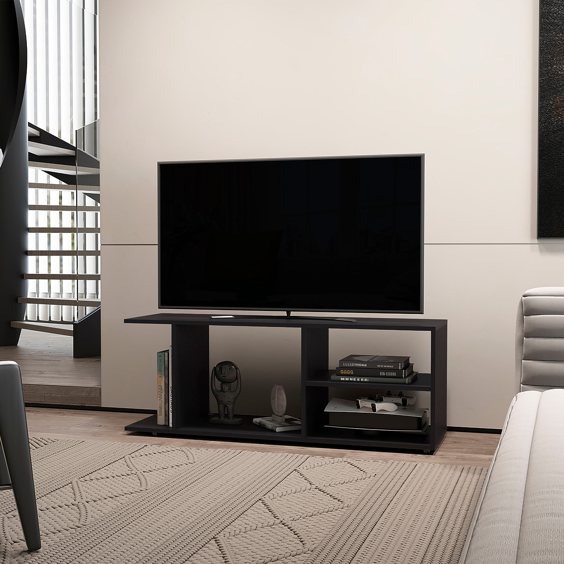 Black media console with open shelves holding books and a game console