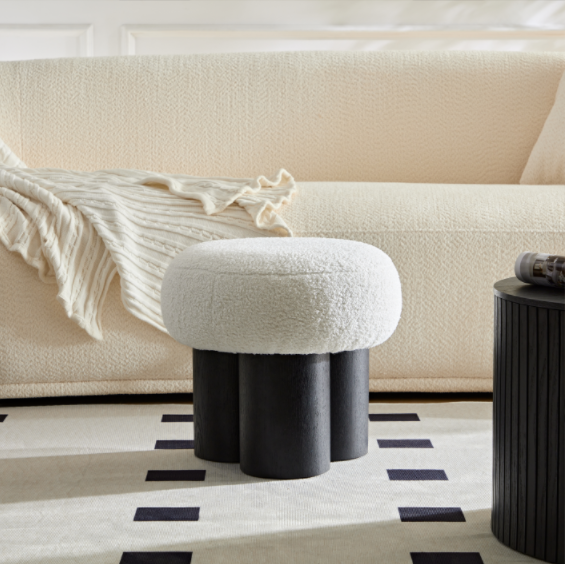 White boucle upholstered ottoman with black wooden legs