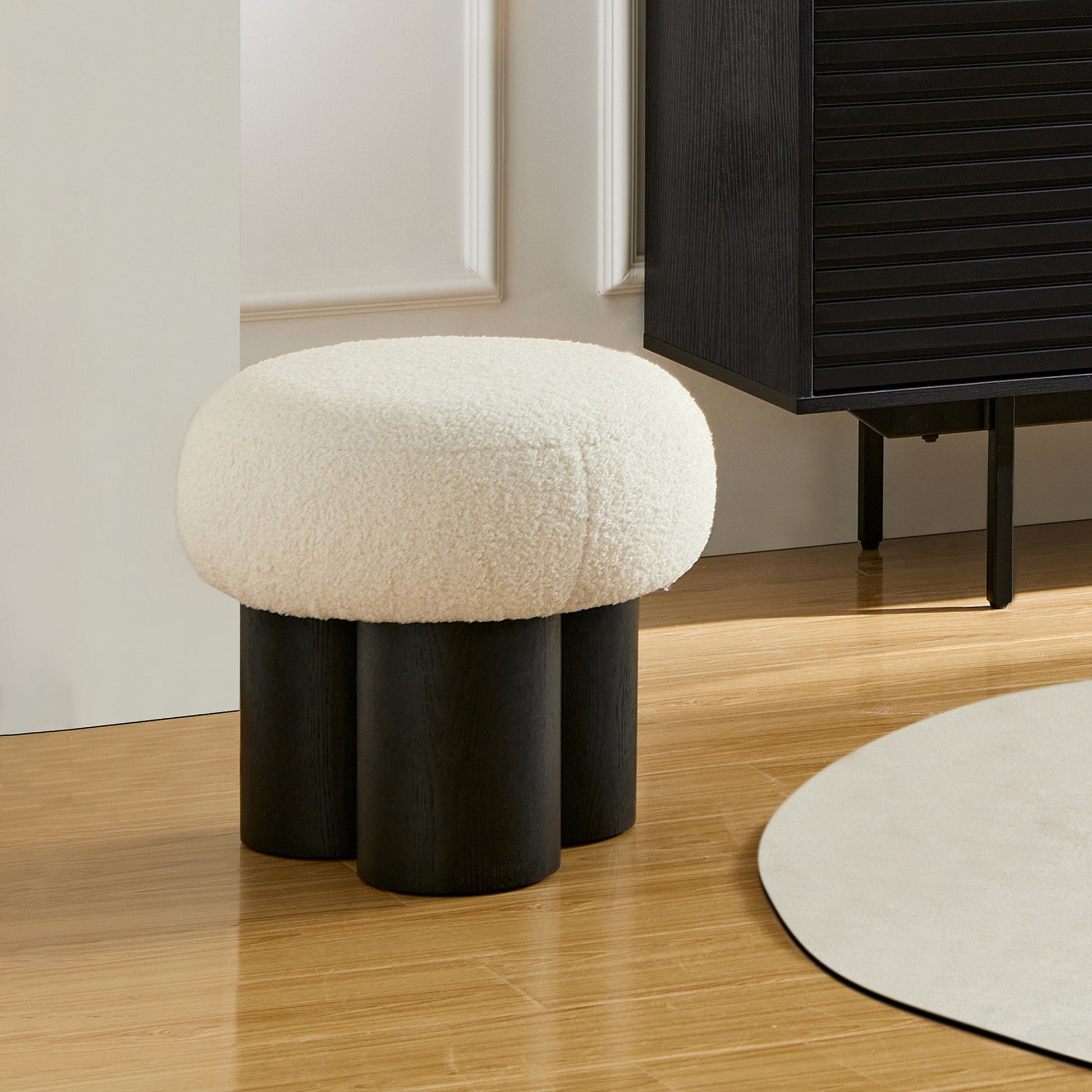 Cream boucle ottoman with black wood legs a stylish accent piece