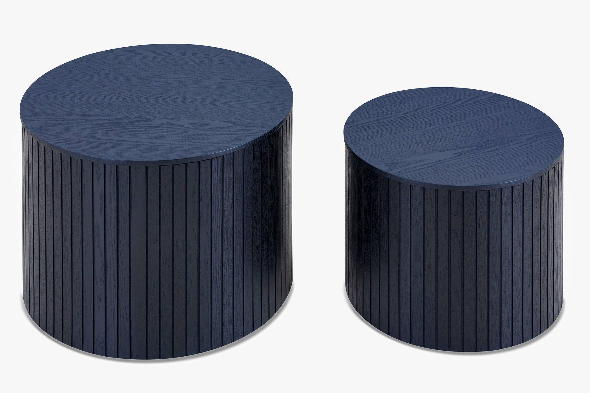 Two dark blue wooden drum side tables with fluted detailing